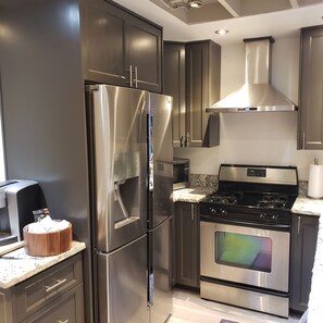 A modern kitchen with stainless steel appliances, including a refrigerator, oven, and microwave. - Charming 2-bedroom A Frame modern cabin in McCall perfect for a cozy getaway (McCall)