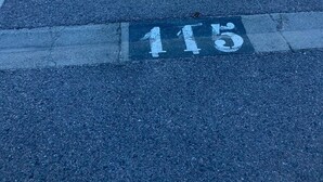 Pysäköintialue, jossa on merkityt pysäköintiruudut, mukaan lukien invapaikka, jonka numero on 113.