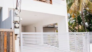 En toetages boligbygning med balkon, garageport og en træport.