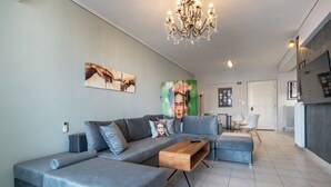 Un soggiorno moderno con un divano ad angolo grigio, un tavolino in legno e un lampadario.