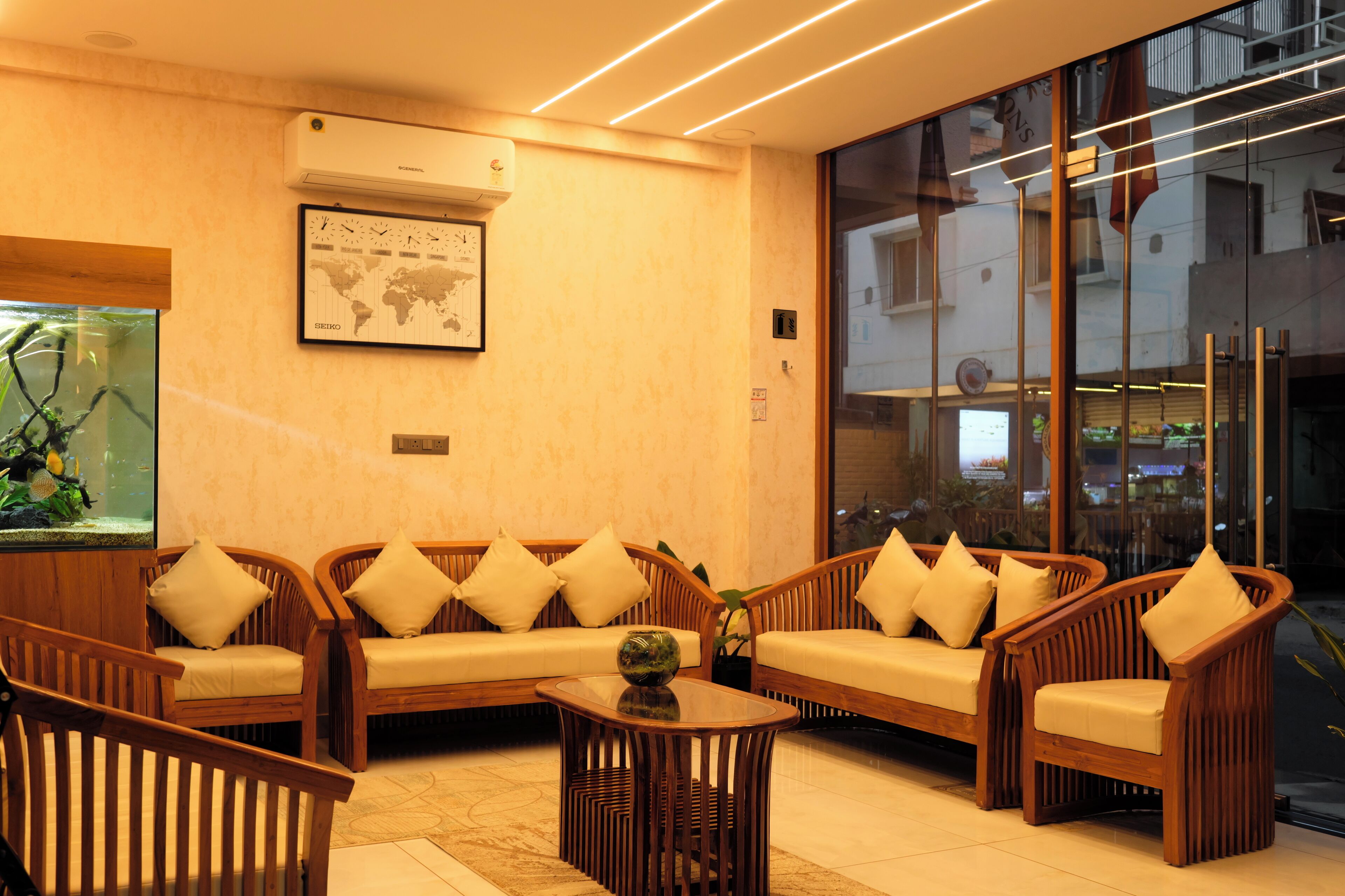 A modern lounge area with wooden furniture and a large aquarium.