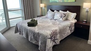 A hotel room with a large bed, two bedside tables, a ceiling fan, and a view of the outdoors. - Cozy 2-bedroom condo with AC in peaceful North Myrtle Beach with amazing view (North Myrtle Beach)