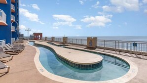 A pool area with lounge chairs and a view of the sea. - Cozy 2-bedroom condo with AC in peaceful North Myrtle Beach with amazing view (North Myrtle Beach)