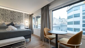 A modern hotel room with a bed, a sofa, a round table, and chairs. - 302 — SB20 Boutique Studios | 1BR | 1BA | W/K (Madrid)