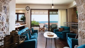 Ein Zimmer mit Meerblick, einem Essbereich und einer durchgehenden Tür erkennbaren Küche.