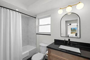 Ein modernes Badezimmer mit Badewanne, Toilette und Waschtisch.