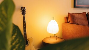 A guitar, a lamp, and a couch in a room. - Modern, Spacious Apartment — Your Home Away From Home (Dar es Salaam)