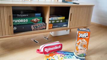 A wooden entertainment unit with board games and a television.