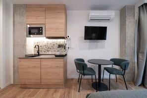 Une cuisine compacte équipée d’un four à micro-ondes, d’un évier et d’un petit coin repas avec des chaises.