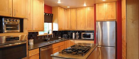 A modern kitchen with wooden cabinets, stainless steel appliances, and a central island.