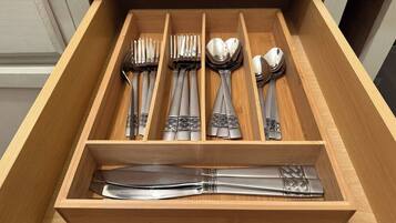 A drawer with neatly organized cutlery including forks, spoons, and knives.