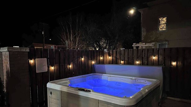 Un jacuzzi con cubierta de madera y pared de ladrillo.