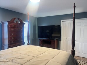 A bedroom with a bed, dresser, television, and a door. - Blues City Nest
A Cozy 2-bedroom 1/12 bath house in central Memphis Tennessee. (Memphis)