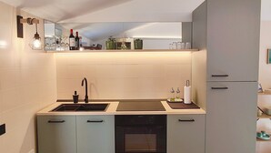 Eine moderne Küche mit Einbauofen, Spüle und Arbeitsplatte mit Spiegel darüber.