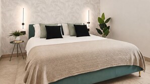 Ein Schlafzimmer mit einem Bett, Nachttischen, einer Zimmerpflanze und einer Klimaanlage.