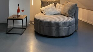 A cozy, circular bed with a striped headboard in a sloped ceiling room with a skylight. - WeinZeit4 - Premium time out at the Frank Meyer winery (Gleiszellen-Gleishorbach)