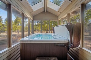 A hot tub with a wooden interior and glass walls, surrounded by a wooden deck and trees. - North Sunriver Getaway with Access to The Cove (Sunriver)