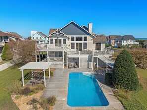 A two-story house with a pool, a covered patio, and a view of the ocean. - Eventide: Views of the Golf Course | Private Pool | Ensuite Bedrooms (Corolla)