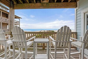A wooden deck with white Adirondack chairs and a view of the beach. - Libby's Keep: Oceanfront | Elevator (Rodanthe)
