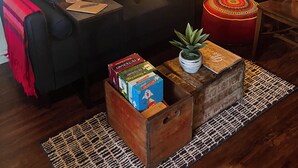 A cozy living room with a sofa, colorful pillows, a wooden coffee table, and a lamp.