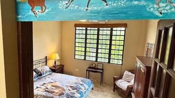 Un dormitorio con cama, mesita de noche, lámpara, ventana y armario.