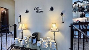 A kitchen area with a coffee station featuring a coffee maker and multiple cups and saucers. - Vieques BioBay Bed and Breakfast (Vieques)