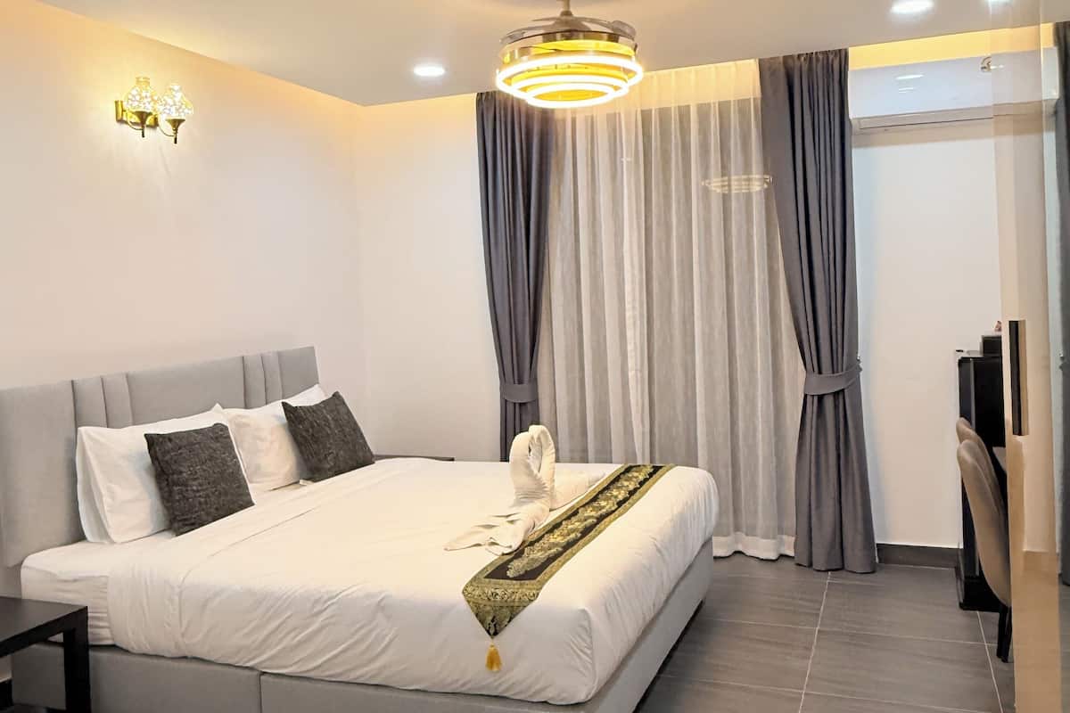 Een moderne hotelkamer met een groot bed, een bureau en een stoel.