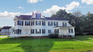 A large, two-story house with a prominent gable roof and multiple windows. - Keepsake Inn - Where Memories are Made (Colebrook)