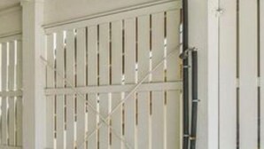 Un parcheggio sotterraneo con cancelli in metallo bianco e pavimento in cemento.