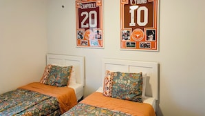A bedroom with two single beds, each with floral-patterned bedding and matching pillows.