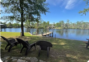 A lakeside view with a dock, chairs, and a gazebo. - Waterfront River House on Brices Creek, New Bern (New Bern)