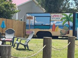 A food truck with a beach-themed design, including a turtle and palm trees. - Waterfront River House on Brices Creek, New Bern (New Bern)