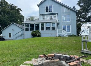 A two-story light blue house with a balcony, a visible staircase, and a grassy yard. - Waterfront River House on Brices Creek, New Bern (New Bern)