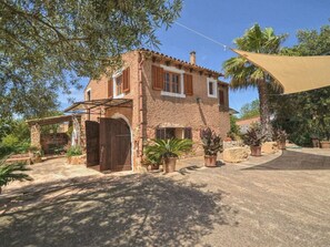A rustic stone house with a tiled roof, wooden shutters, and a covered patio area. - MONTSERRAT  ( SON PERETO ) by Interhome (Manacor)