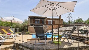 A poolside area with lounge chairs, a large umbrella, and a stone staircase leading to a building with a tiled roof. - MONTSERRAT  ( SON PERETO ) by Interhome (Manacor)