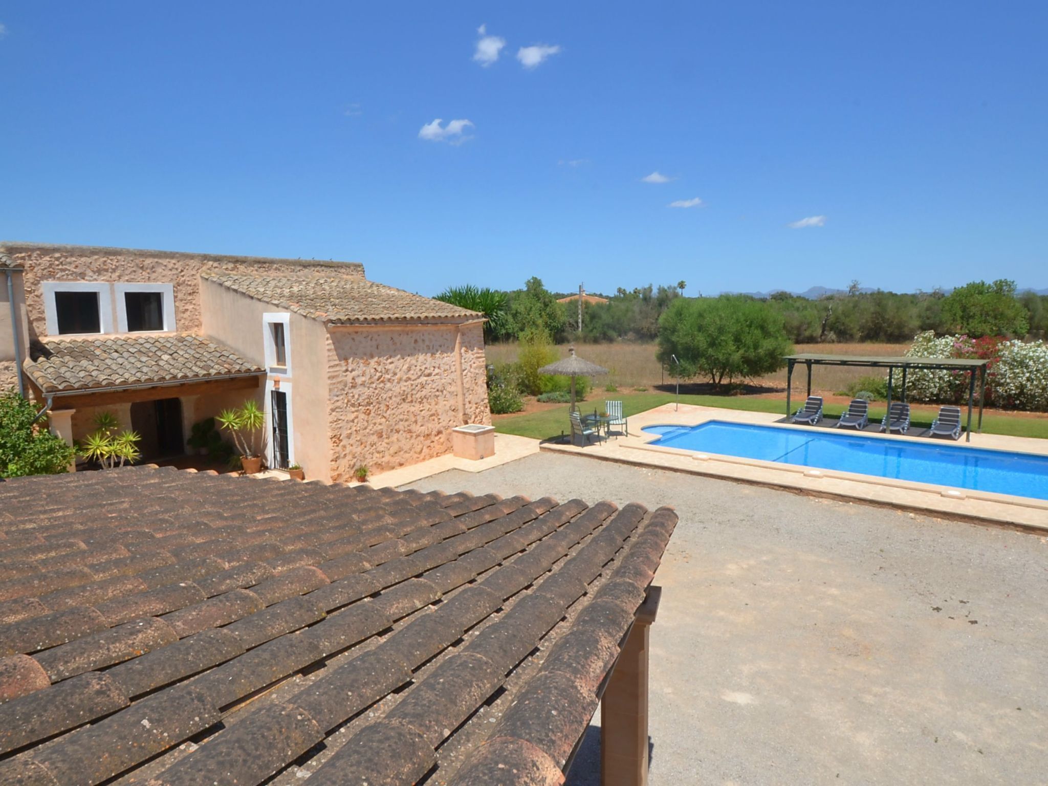 Ein Haus mit Swimmingpool, einer Terrasse mit Stühlen und Blick auf die Landschaft.