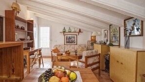 Una sala de estar acogedora con una mesa de comedor de madera, un sofá y un aparador.