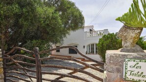 Una rústica puerta de madera que da a un edificio blanco con base de piedra y un letrero que dice 'Las Tortolias'.