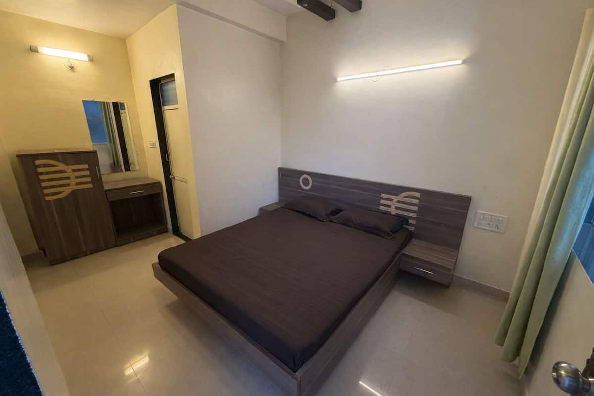 Ein Schlafzimmer mit einem Bett, Nachttischen, einem Kleiderschrank und einem Spiegel.