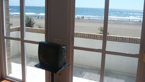 A room with large windows overlooking a beach. - Wohnung in Torrox mit Großem gemeinsamem Pool und Meerblick by Interhome (La Axarquía/ Torrox)