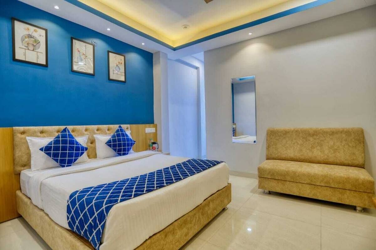 Ein Schlafzimmer mit Bett, einer Couch und Bildern an der Wand.