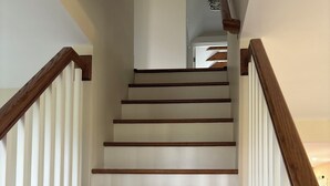 A wooden staircase with white walls and a ceiling light fixture. - Wine Trail and Sunset Vibes in this Welcoming 3-bedroom home in Cayuga! (Cayuga)