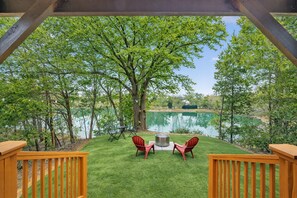A deck with a view of a lake, surrounded by trees. - The Doodle House Lake Front Tiny, Home Kayak, Miniature Golf, fishing, (Bastrop County)
