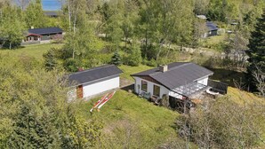 Un quartiere residenziale con case circondate da alberi e uno specchio d'acqua sullo sfondo.