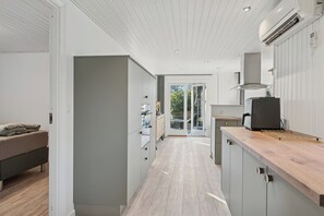 A modern kitchen with a wooden countertop, grey cabinets, and a built-in oven. - Quiet holiday in Hemmet 300 m to water (Hemmet)