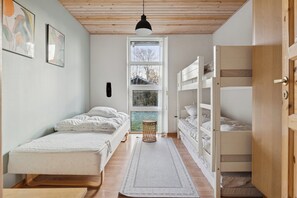 Un dormitorio con una cama litera, una cama individual, una ventana y una puerta.