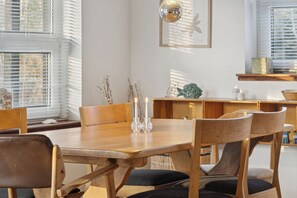 A dining area with a wooden table, chairs, candles, and a disco ball. - Cozy wooden cottage close to nature and beach (Vig)