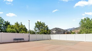 An outdoor patio area with a white fence, a bench, and a street lamp. - Grand Mountain Retreat: Hot Tub, Sleeps 21, Sofa Sleeper on Main Floor (Draper)