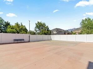 An outdoor patio area with a white fence, a bench, and a street lamp. - Grand Mountain Retreat: Hot Tub, Sleeps 21, Sofa Sleeper on Main Floor (Draper)