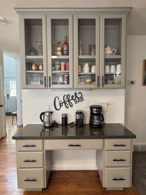 Eine Küche mit einer Kaffeebar, Schränken und verschiedenen Küchengeräten.